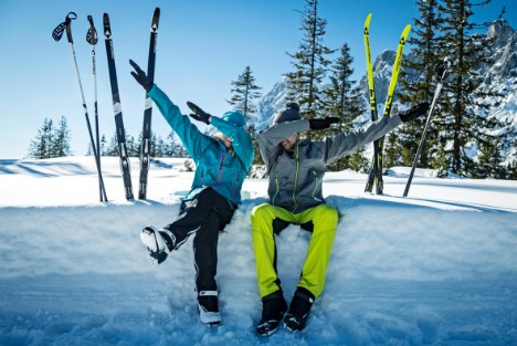 Langläufer sitzten im Schnee und machen ein Dab